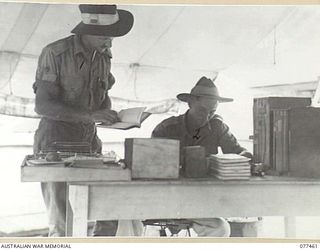 LAE BASE AREA, NEW GUINEA. 1944-12-04. VX85195 STAFF SERGEANT ATKINSON (1); AND WX4563 WARRANT OFFICER II, R.B. JOHNSON (2) BOOKING IN A MOTOR VEHICLE FOR REPAIRS AT THE 2/77TH LIGHT AID ..