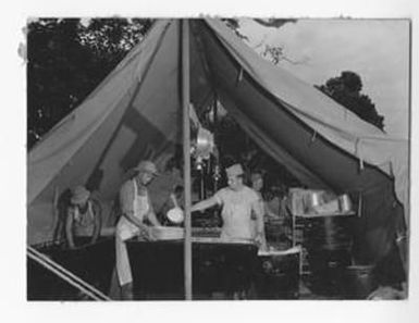 [Men Preparing Food Under A Tent]