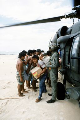 Villagers help unload supplies from a 53rd Aviation Battalion UH-60 Black Hawk helicopter following its arrival on the island of Savaii. Military personnel from the United States and other nations are providing such services to Savaii and the island of Upolu as part of disaster relief efforts in the aftermath of Cyclone Ofa