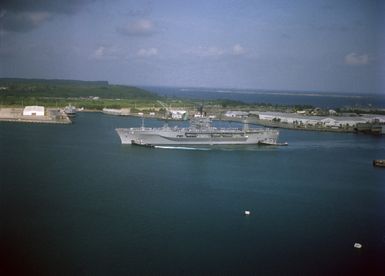 Large harbor tugs maneuver the amphibious command ship USS BLUE RIDGE (LCC 19) into the harbor