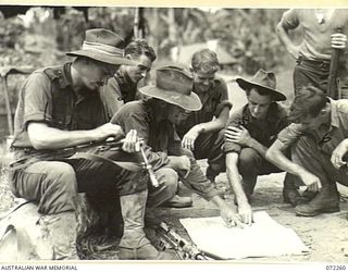 DUMPU, NEW GUINEA. 1944-04-03. MEMBERS OF THE 57/60TH INFANTRY BATTALION CLEANING GUNS AND CHECKING THEIR MAPS DURING A HALT ON THE BOGADJIM ROAD. IDENTIFIED PERSONNEL ARE:- VX81104 LIEUTENANT F.J. ..