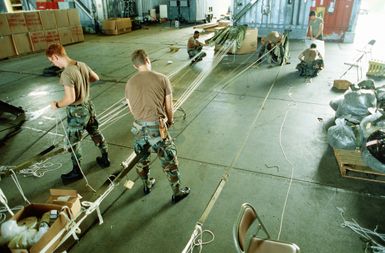 Members of the 8th Mobile Aerial Port Squadron check suspension lines on parachutes to be used during Christmas Drop. The annual airdrop is a humanitarian effort providing aid to needy islanders throughout Micronesia during the holiday season