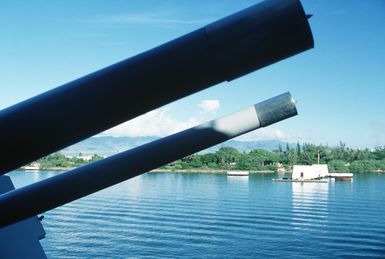 Mark 28 5-inch gun barrels of the battleship USS MISSOURI (BB 63) frame the USS ARIZONA Memorial as the ship passes by during a re-enactment of the Great White Fleet's salute to Kalaupapa which took place in 1908. Kalaupapa is a leper settlement located on the northern coast of Molokai, Hawaii
