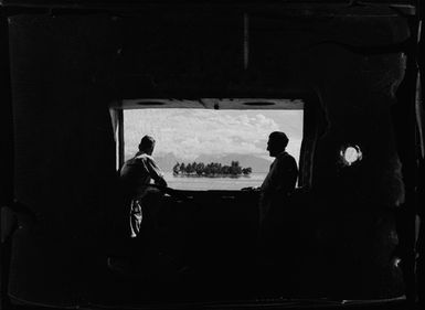 [Two men with window view of an island]