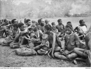 KIARIVU, NEW GUINEA, 1945-08-17. REFUGEE NATIVES LINED UP ON THE AIRSTRIP FOR COUNTING AND INSPECTION BY CAPTAIN R.R. COLE, THE ASSISTANT DISTRICT OFFICER, AUSTRALIAN NEW GUINEA ADMINISTRATIVE ..