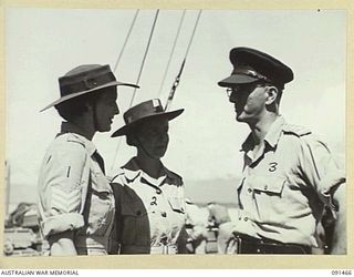 LAE, NEW GUINEA, 1945-05-07. LIEUTENANT-COLONEL W.E. HOLMES, OFFICER COMMANDING TROOPS ABOARD THE MV DUNTROON (3), RECEIVING DECK REPORTS FROM B DECK AUSTRALIAN WOMEN'S ARMY SERVICE SERGEANTS. THE ..
