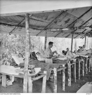 ORO BAY, NEW GUINEA. 1943-07. PRIVATE L.E. CHAMPION, MEDICAL ORDERLY, ATTENDING TO PATIENTS IN THE SCRUB TYPHUS WARD AT THE MAIN DRESSING STATION, 10TH FIELD AMBULANCE