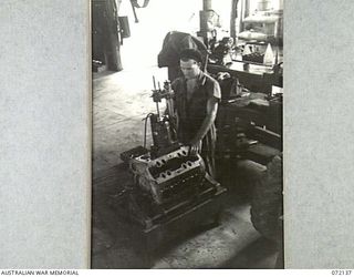 PORT MORESBY, NEW GUINEA. 1944-04-10. VX143788 CRAFTSMAN R.G. WESTLEY RE-BORING AN ENGINE AT THE 11TH ADVANCED WORKSHOP, AUSTRALIAN ELECTRICAL AND MECHANICAL ENGINEERS