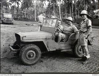 MILNE BAY, PAPUA. C. 1942-10. TWO UNITED STATES OFFICERS AND A RAAF PILOT AT THE GURNEY AIRSTRIP ON A SECTION COVERED WITH METAL AIRSTRIP MATTING