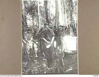 28 OCTOBER 1943. FARIA VALLEY, NEW GUINEA. PADRE H. NORMAN OF CHRIST CHURCH, NORTH ADELAIDE, CONDUCTING A MEMORIAL SERVICE FOR SOLDIERS KILLED IN THE FARIA VALLEY SECTION. (NEGATIVE BY G. SHORT)