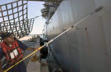 U.S. Navy Fire Controlman Third Class Vernon McDaniel paints the side of the Arleigh Burke Class Guided Missile Destroyer USS HOPPER (DDG 70), during a port visit to Guam on Sep. 4, 2006. The HOPPER is on a scheduled deployment in support of Maritime Security Operations and the Global War on Terrorism.(U.S. Navy photo by Mass Communication SPECIALIST Second Class John L. Beeman) (Released)