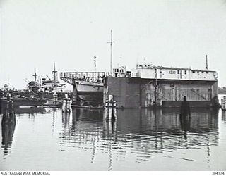 MANUS ISLAND, ADMIRALTY ISLANDS. 1949-09. VIEW OF THE PORT FACILITIES WITH A GENERAL PURPOSE VESSEL IN FLOATING DOCK AD 301. ALONGSIDE THE WHARF IN THE BACKGROUND ARE THE BURNS PHILP VESSEL MALAITA ..