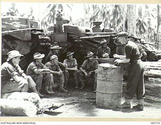 MADANG, NEW GUINEA. 1944-10-12. SERGEANT SUTCLIFFE, ROYAL ARMOURED CORPS (1), INSTRUCTING AUSTRALIAN TROOPS ON DRIVING, MAINTENANCE AND GUNNERY ON CHURCHILL TANKS