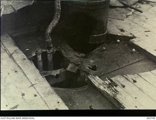 MILNE BAY. C.1943-04-14. DAMAGE TO THE FORECASTLE DECK AT THE FOOT OF THE VENTILATOR ABAFT THE 12 POUNDER GUN OF HMAS PIRIE. IT WAS CAUSED BY A BOMB HIT FROM A JAPANESE AIRCRAFT WHEN THE CORVETTE ..