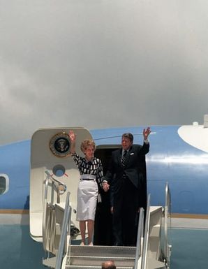 President and Mrs. Ronald Reagan wave to a crowd as they exit Air Force One. The president and first lady are visiting Hawaii while en route to the Republic of China