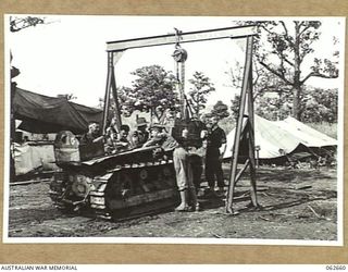 RAMU VALLEY, NEW GUINEA. 1943-12-21. MECHANICS OF THE 53RD AUSTRALIAN FIELD PARK COMPANY, ROYAL AUSTRALIAN ENGINEERS, 7TH AUSTRALIAN DIVISION, LOWERING A RECONDITIONED MOTOR INTO A D4 TRACTOR WITH ..