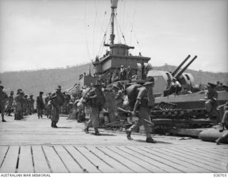 PORT MORESBY, PAPUA. 1942-09. TROOPS OF THE 25TH AUSTRALIAN INFANTRY BRIGADE DISEMBARKING AT THE WHARF FROM NAVAL CORVETTES, HAVING BEEN FERRIED BY THOSE VESSELS FROM TROOPSHIPS ANCHORED IN THE ..