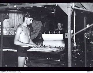 RABAUL, NEW BRITAIN, 1946-03-27. PRIVATE J. EFFENEY (1) AND PRIVATE S.R. KEEL (2) OPERATING THE MOBILE PRINTING PRESS DURING THE PRODUCTION OF THE ARMY NEWSPAPER GUINEA GOLD. THE NEWSPAPER CHANGED ..