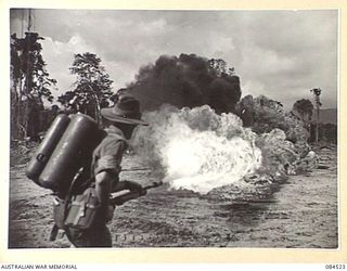 BOUGAINVILLE, SOLOMON ISLANDS. 1944-12-21. AN AUSTRALIAN SOLDIER FROM HEADQUARTERS 3 DIVISION OPERATING A UNITED STATES FLAME THROWER M1A1 ON LIGHT FUEL DURING A DEMONSTRATION