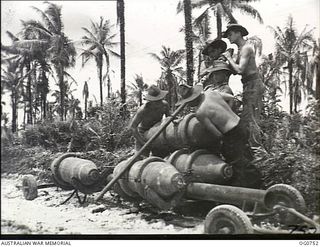 MOMOTE, LOS NEGROS ISLAND, ADMIRALTY ISLANDS. 1944-03-08. RAAF ARMOURERS MANHANDLING BOMBS BEFORE A RAID BY RAAF KITTYHAWK FIGHTER-BOMBER AIRCRAFT FROM MOMOTE AIRSTRIP IN THE ADMIRALTY ISLANDS