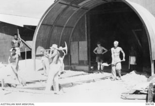 Members of the Japanese War Criminals Construction Unit digging and shovelling as they prepare the foundations to build a store house at the RAN War Criminal Compound at an RAN shore base HMAS ..