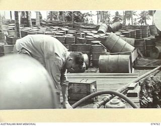 MADANG, NEW GUINEA. 1944. UNITED STATES ARMY PERSONNEL REFUELLING A BARGE AT THE 593RD UNITED STATES BARGE COMPANY REPAIR WORKSHOPS FUEL DUMP