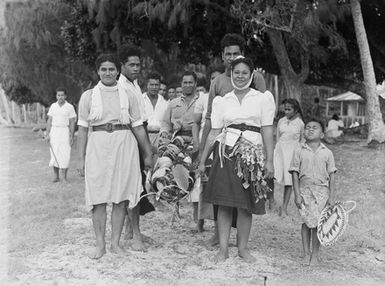 [Group of Polynesian people carrying food]