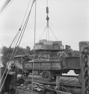 WIDE BAY, NEW BRITAIN. 1945-05-06. A WORKING PARTY FROM 11 INFANTRY BATTALION AT WORK ALONGSIDE THE AK 82 (FORMERLY THE ALMA-DOEPEL) 16 WATERCRAFT COMPANY, ROYAL AUSTRALIAN ENGINEERS, DISCHARGING A ..