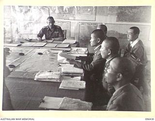 CAPE WOM, NEW GUINEA, 1945-09-13. AT A CONFERENCE BETWEEN STAFF OFFICERS OF 6 DIVISION, HEADED BY LIEUTENANT-COLONEL J. BISHOP GENERAL STAFF OFFICER I, AND JAPANESE STAFF OFFICERS OF 18 JAPANESE ..