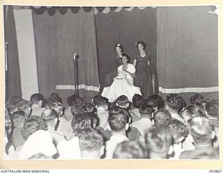 LAE AREA, NEW GUINEA, 1945-07-09. SIGNALWOMEN N.L. EADE (1) PLAYING THE PART OF "MARY" IN "A PRETTY GIRL" DURING THE REVUE "OVER TO YOU". IT WAS STAGED BY 19 LINES OF COMMUNICATION AREA SIGNALS IN ..