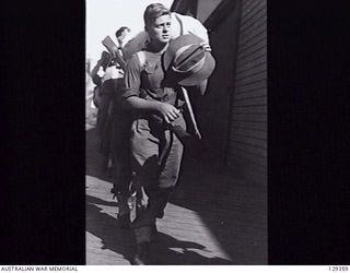 SYDNEY, NSW. 1946-05-16. WX28958 SIGNALMAN R. D. HIGGINS, 8TH M. D. SIGNALS, RETURNING HOME, AT CIRCULAR QUAY AFTER DISEMBARKING FROM THE TROOPSHIP CANBERRA, ON ITS ARRIVAL FROM RABAUL