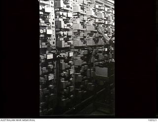 Lae, New Guinea. 1944-06-18. A signaller of 5 Carrier Maintenance Section working on a 40 CI Telegraph Equipment Panel at the Carrier Terminal Station, Lae Base Sub Area