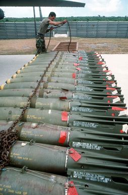 AIRMAN 1ST Class Ron Diego, a munitions specialist with the 43rd Bomb Wing, removes a chain from a row of Mark 82 500-pound bombs during exercise Giant Warrior '89
