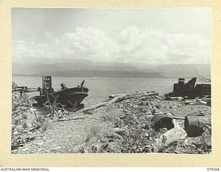 KAMANDRAN MISSION, NEW BRITAIN. 1945-02-17. SOME OF THE WRECKED JAPANESE BARGES ON THE BEACH NEAR THE MISSION MISSION IN THE HEADQUARTERS, 5TH DIVISION AREA