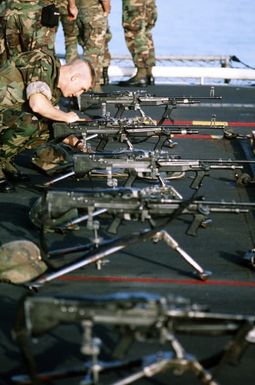 A Marine of the 22nd Marine Expeditionary Unit (22nd MEU) adjusts one of the M-60E3 machine guns set up on the flight deck of the amphibious assault ship USS SAIPAN (LHA-2) for weapons training prior to Operation Sharp Edge. The SAIPAN is on station off the coast of Liberia