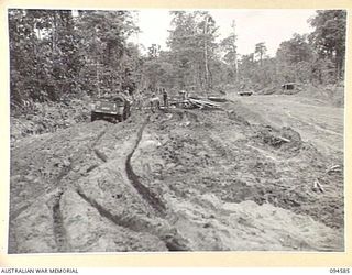 BOUGAINVILLE, 1945-07-31. A JEEP OF 29 INFANTRY BRIGADE TRAVERSING THE OLD BUIN ROAD WHICH HAS BECOME A QUAGMIRE DUE TO HEAVY RAIN. ON THE RIGHT A NEW 3-TONNER ROAD, CONSTRUCTED BY 15 FIELD ..