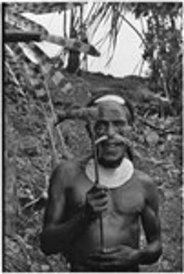 Bride price for Maima: man wearing shell valuables holds stone axe, which will be included in bride price exchange