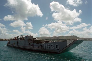 The US Navy (USN) Utility Landing Craft (LCU 1630) prepares to ferry a load of military equipment ashore at the Sierra Pier, Guam during Exercise TANDEM THRUST 99