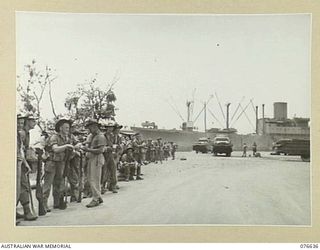 LAE, NEW GUINEA. 1944-11-02. PERSONNEL OF A COMPANY, 14/32ND INFANTRY BATTALION LINED UP ON THE BEACH AWAITING ORDERS TO EMBARK ABOARD THE TROOPSHIP "CAPE ALEXANDER"