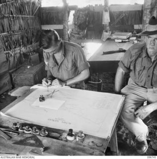 KARAWOP, NEW GUINEA, 1945-09-18. CPL A.E. BIRCH (1) AND TPR R.G. WELLS (2), 2/6 CAVALRY COMMANDO REGIMENT INTELLIGENCE SECTION, IN THE INTELLIGENCE HUT