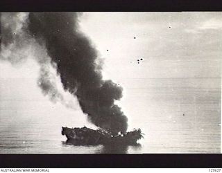 HUMBOLDT BAY, NEW GUINEA. 1944-04-03. CAMOUFLAGED BARGE CAUGHT BY B25 BOMBER AIRCRAFT OF FIFTH AIR FORCE, UNITED STATES ARMY AIR FORCE, AND LEFT IN FLAMES