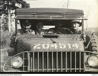VIVIGANI, GOODENOUGH ISLAND, PAPUA. C. 1943-11. RAAF PUBLIC RELATIONS PARTY IN THEIR VEHICLE NO. RAAF 204514. LEFT TO RIGHT: FLIGHT LIEUTENANT (FLT LT) JOHN HARRISON, OFFICIAL PHOTOGRAPHER; PILOT ..