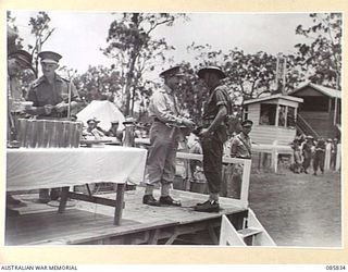 HERBERTON, QLD. 1945-01-19. LIEUTENANT GENERAL SIR LESLIE J MORSHEAD, GENERAL OFFICER COMMANDING 1 CORPS, (3), PRESENTING SERGEANT SHARPE, (4), WITH THE PRIZE WON BY HQ 24 INFANTRY BRIGADE TROOPS ..