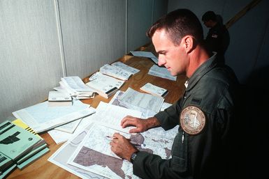 1ST LT. Mike Mathews, co-pilot of a KC-10A Extender aircraft, prepares for a Military Airlift Command channel cargo mission in the base operations center. LT. Mathews is a member of the 6th Air Refueling Squadron, 22nd Air Refueling Wing, March Air Force Base, California