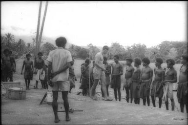 Brian McBarron (Agricultural Officer) dispensing yams after drought (1) : Goodenough Island, D'Entrecasteaux Islands, Papua New Guinea, 1956-1958 / Terence and Margaret Spencer