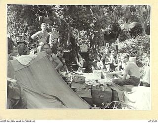 KALAI PLANTATION, NEW BRITAIN. 1945-02-17. PERSONNEL OF A COMPANY, 19TH INFANTRY BATTALION RELAXING AT A MEAL IN THEIR JUNGLE KITCHEN