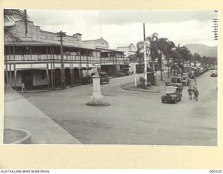 ATHERTON, QUEENSLAND, AUSTRALIA. 1944-10-06. THE MAIN STREET SHOWING THE ARMY VEHICLE PARK. HERBERTON LIES AT THE BACKGROUND. THE 1914-18 WAR MEMORIAL IS AT CROSSROADS IN THE FOREGROUND