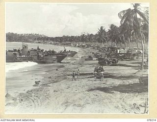 AITAPE, NEW GUINEA. 1945-01-08. A BUSY SECTION OF THE BEACH SHOWING TWO AMERICAN LST (LANDING SHIP, TANK) UNLOADING SUPPLIES FOR THE 6TH DIVISION IN THE FOREGROUND