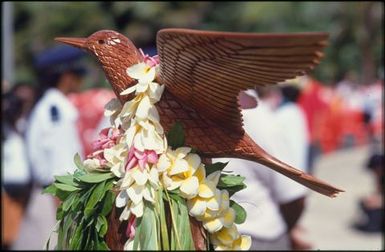 Carved wooden bird with lei