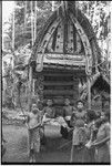 Yam house of the chief of Omarakana has a decorated facade and is full of yams, boys hang out